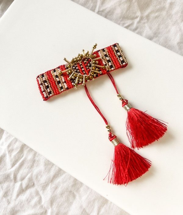 Pulsera tejida con corazón rojo